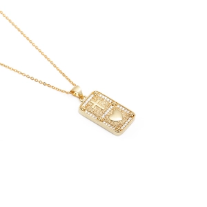 Gold necklace with rectangular cross and heart pendant adorned with sparkling crystals
