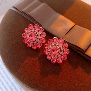 Macro detail of pink crystal flower earrings with sparkling rhinestones and silver pins
