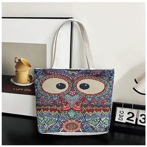 Detailed weave texture of canvas tote bag featuring a colorful owl embroidery design