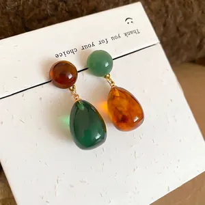 Retro asymmetric resin teardrop earrings with silver needles in amber and green finish