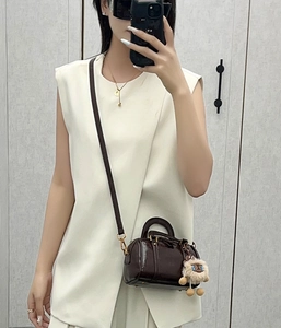 Dark brown leather Boston bag with plush sheep charm worn by model in mirror selfie