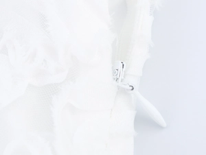 Detail showing a seamless white invisible zipper on premium mesh lace evening dress fabric