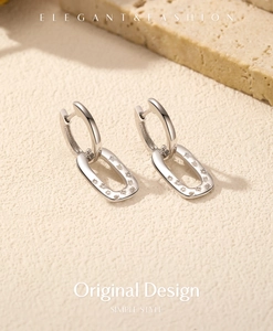 Macro view of silver geometric hoop earrings with sparkling zircon crystals in minimalist style