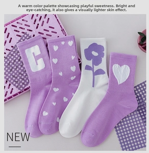 Detail view of four pairs of cotton crew socks in purple and white with heart patterns