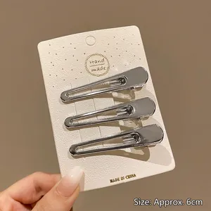 Détail de pinces à cheveux Y2K en métal argenté sur carte avec mesure de 6cm environ