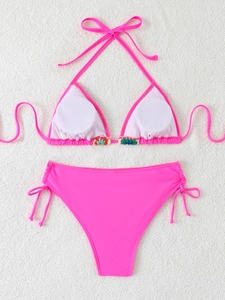 Detail of neon pink bikini with ethnic style embroidery on triangle top and high waist bottom