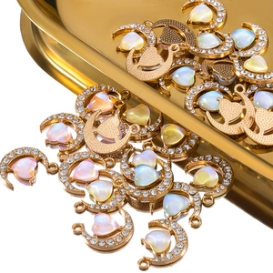 Macro shot of 19mm gold moon heart pendants with opal stones and sparkling rhinestones