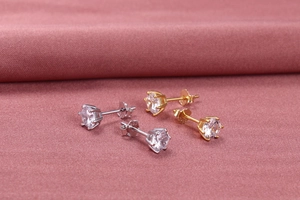 Detailed macro view of S925 sterling silver six-prong stud earrings in gold and silver