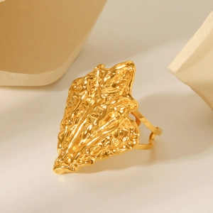 Detailed close-up of golden stainless steel ring with irregular hammered lava texture