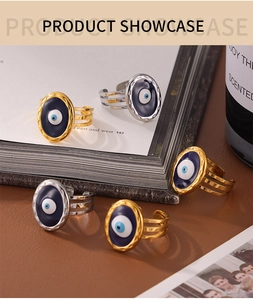 Detail view of gold and silver evil eye rings with hollow design on warm textured surface