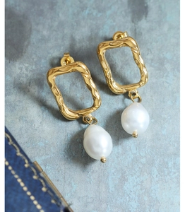 Macro detail of 18K gold irregular geometric earrings with hanging teardrop pearls