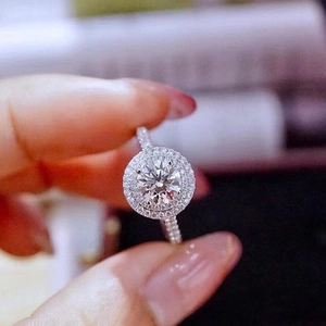 Detailed view of a silver-tone halo ring featuring a round center stone and paved band