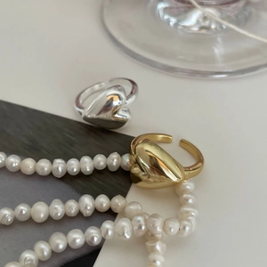 Polished 925 sterling silver and gold heart-shaped open rings with a pearl background