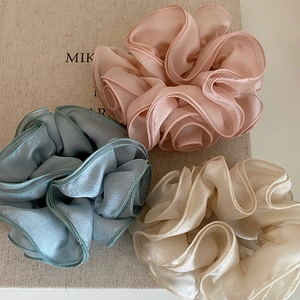 Three elegant ruffle satin scrunchies in pink, blue, and white for stylish ponytails