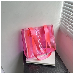 Detail view of pink semi-transparent PVC tote bag with high-density webbing handles