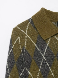 Detailed close-up of argyle knit pattern and texture on olive green polo sweater