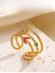 Macro shot of gold-plated triple band ring with colorful enamel stars and moon charms