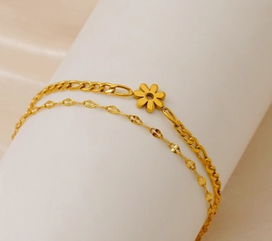 Detail of 18K gold-plated double-layer Figaro bracelet with delicate daisy pendant