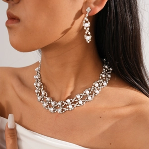 Close-up of elegant double-layer floral necklace and earrings with rhinestones and pearls