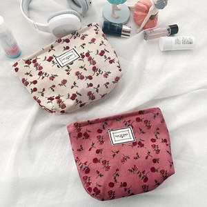 Detail of floral corduroy makeup bags with Time to Party tags on white fabric
