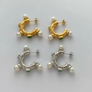 Retro geometric earrings with green zircon and pearls on stylized magazine background