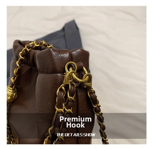 Detail einer dunkelbraunen Lederhandtasche mit hochwertigem goldenem Karabinerverschluss