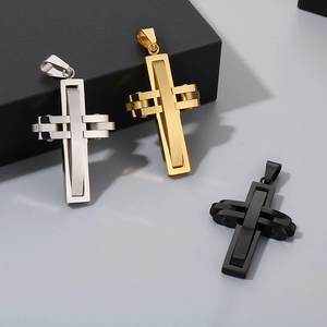 Three cross pendants in silver, gold, and black finishes on a grey background