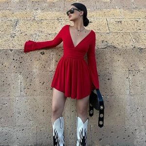 Detail of red deep V-neck dress showing waist pleats and lightweight fabric texture