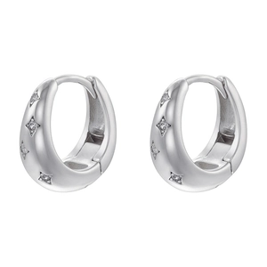 Dettaglio ravvicinato di orecchini huggie argento con zirconi a forma di stella a quattro