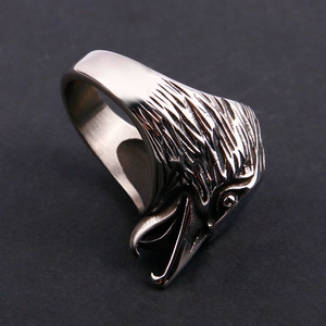 Macro shot of silver eagle head ring showing detailed feather texture and polished steel