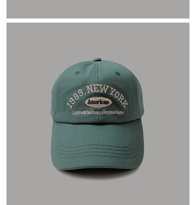 Detailed close-up of 1989 New York white embroidery on dark green vintage cotton cap