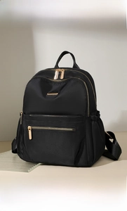 Detail of vintage nylon backpack with gold zippers and large side pockets in black