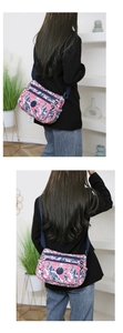 Detailed view of women's nylon crossbody bag with pink and blue camouflage pattern and zippers