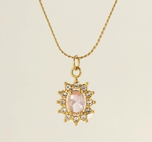 Close-up of golden necklace with heart shaped flower pendant and pink zirconia stone