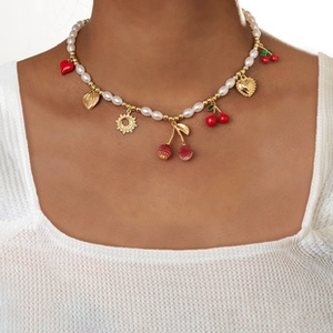 Detail of beaded pearl necklace with red heart, sunflower, and cherry charms