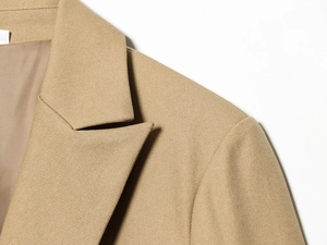 Detailed view of the lapel and shoulder seams on this khaki twill fabric blazer