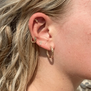 Gros plan de boucles d'oreilles en acier titane doré avec créoles et clous en zircone