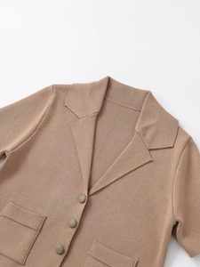 Close-up of lapel collar and button closure on brown short sleeve knit cardigan