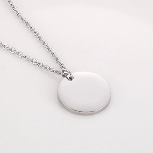 Gros plan d'un pendentif circulaire en acier poli sur un collier à chaîne fine o-chain