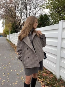 Detail of houndstooth short coat with double-breasted design and lapel collar