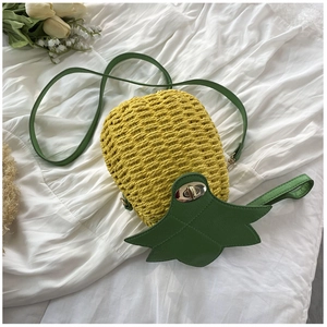Close-up of woven pineapple bag with green leaf flap and silver metal twist lock