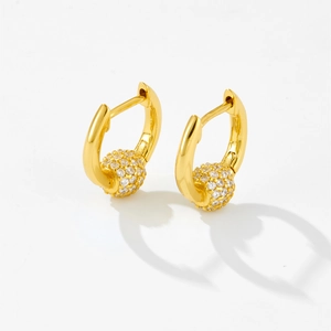 Macro detail of gold-plated hoop earrings with micro-pave white zircon spheres