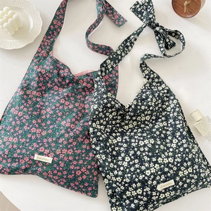 Flat lay of floral canvas tote bags with Sorakka brand label and aesthetic lifestyle props