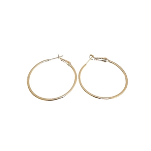 Minimalist glossy gold hoop earrings with silver pins on a white background