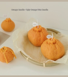 Macro shot of orange-shaped candle with realistic peel texture and VISSY brand tag