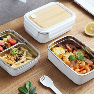 Close-up of portable bento box with bamboo lid and stainless steel divided compartments