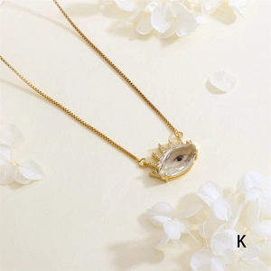 Close-up of gold plated evil eye pendant with zircon details on a fine box chain