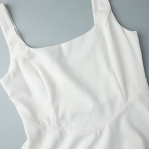 Détail de la robe blanche à col carré montrant les coutures et la texture du tissu