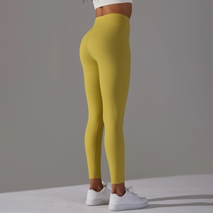 Close-up side view of mustard yellow high-waisted yoga pants on model with lifting effect