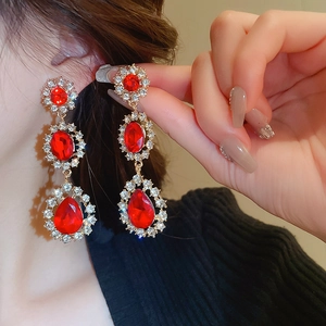 Détail des boucles d'oreilles vintage avec pierres rouges et strass étincelants